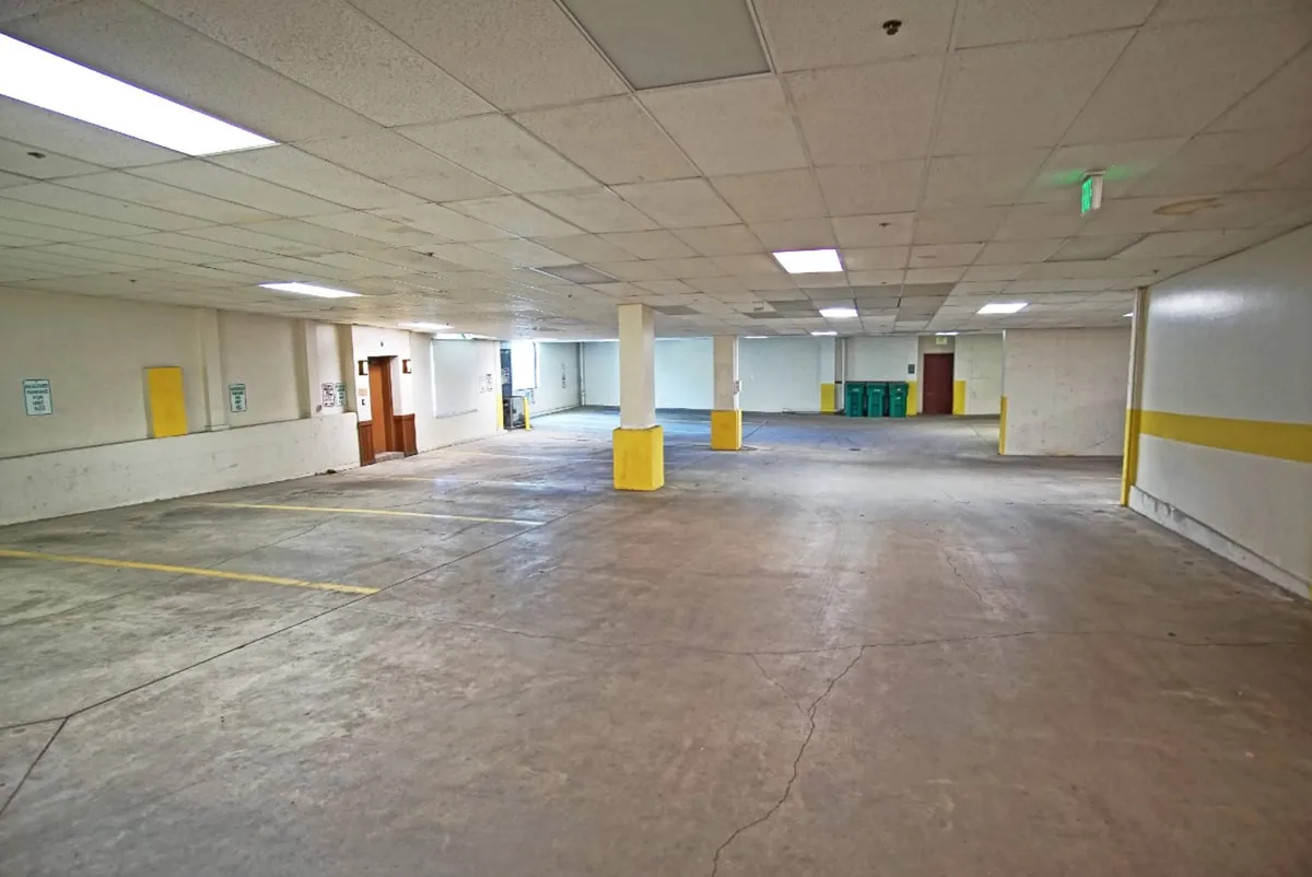 This image displays an interior garage area with yellow pillars, well-lit spaces, and multiple empty parking spots. The clean, spacious environment emphasizes safety and ease of access for guests arriving by car.